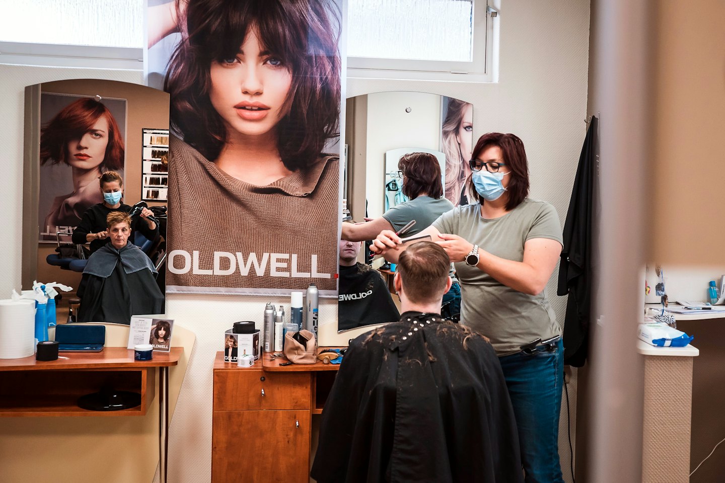 Fryzjerka strzygąca klienta w profesjonalnym salonie.